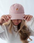 Das Model trägt eine rosa Vintage Cap mit dezent gesticktem Pizza Motiv
