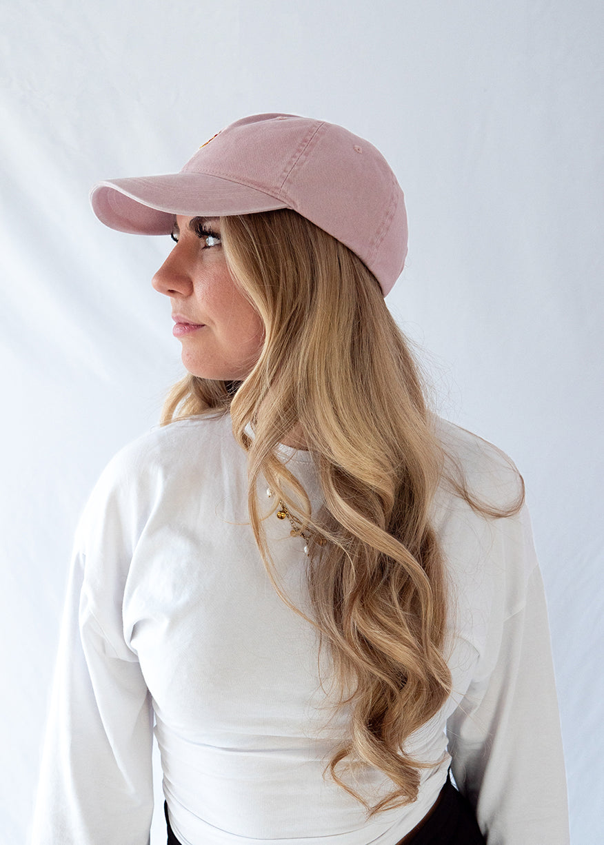 Das Model trägt eine rosa Vintage Cap mit dezent gesticktem Pizza Motiv in der Profil Ansicht