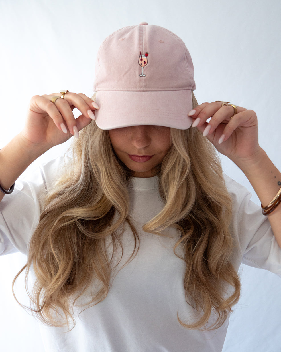 Das Model trägt eine rosa Vintage Cap mit dezent gesticktem Wildberry Glas Motiv