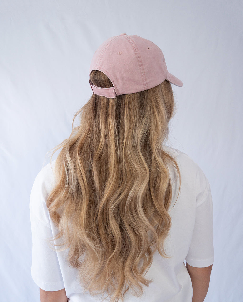 Das Model trägt eine rosa Vintage Cap mit Wildberry Glas Motiv in der Ansicht von hinten