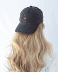 Das Model trägt eine schwarze Vintage Cap mit dezent gesticktem Aperol Spritz Motiv rückwärts