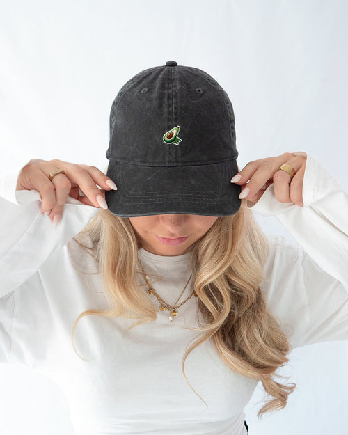 Das Model trägt eine schwarze Vintage mit dezent gesticktem Avocado Motiv