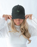 Das Model trägt eine schwarze Vintage Cap mit gesticktem T-Rex Motiv auf der Front