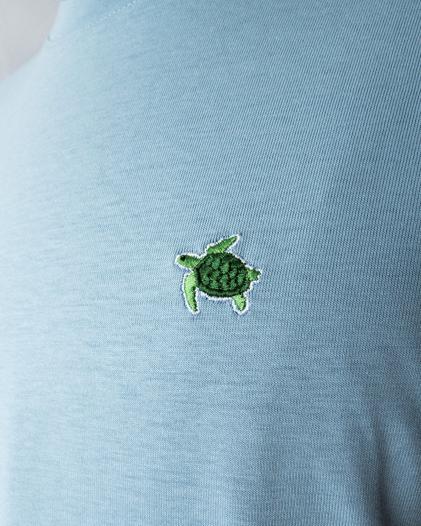 Nahaufnahme des gestickten Schildkröten Motivs auf blauem T-Shirt