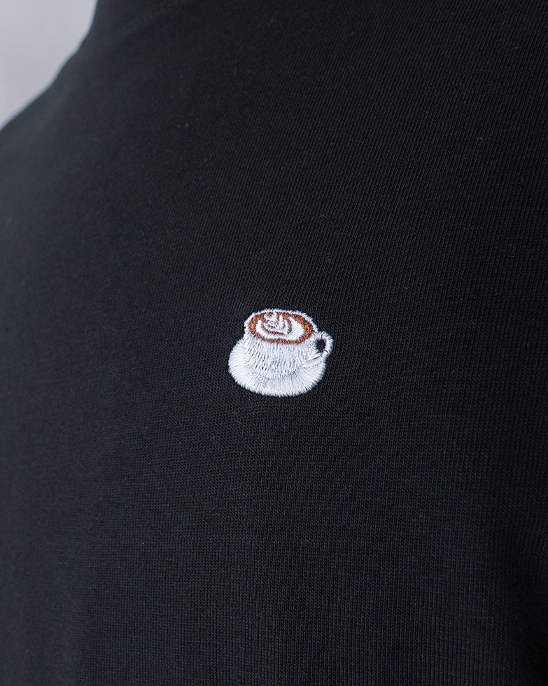 Nahaufnahme des gestickten Kaffe mit Latte Art Motiv auf schwarzem T-Shirt