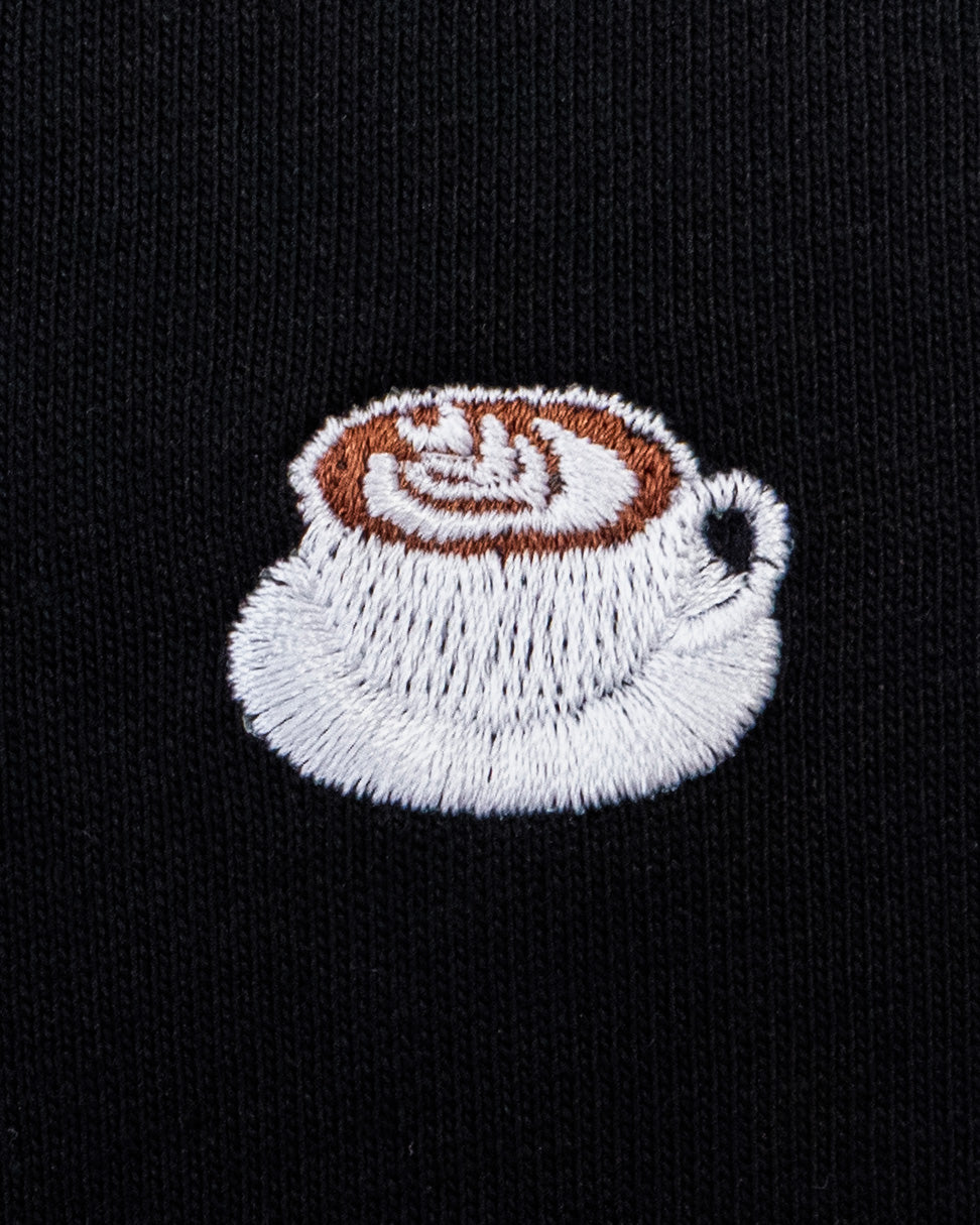 Nahaufnahme des gestickten Kaffe mit Latte Art Motiv auf schwarzem T-Shirt