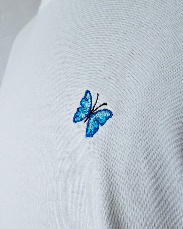 Nahaufnahme des gestickten Schmetterling Motivs auf weißem T-Shirt