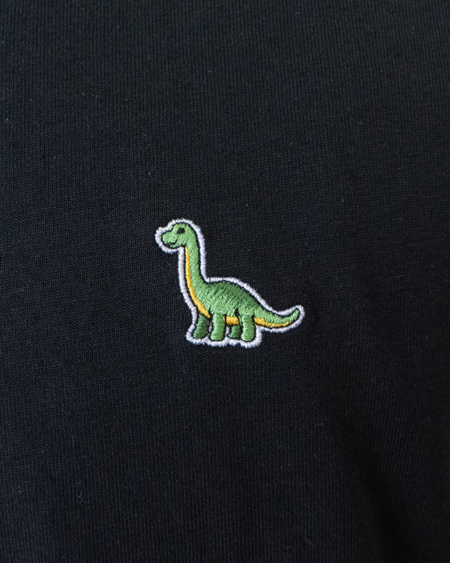 Nahaufnahme des gestickten Brontosaurus Motivs auf schwarzem T-Shirt