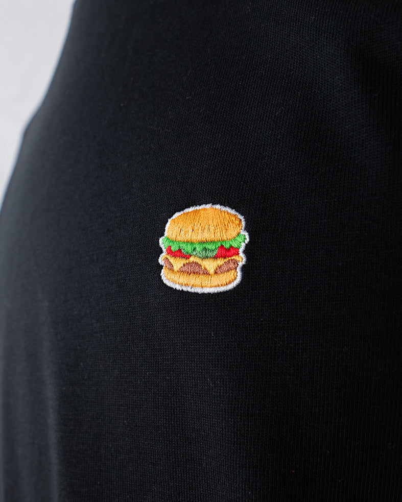 Nahaufnahme des gestickten Burger Motivs auf schwarzem T-Shirt