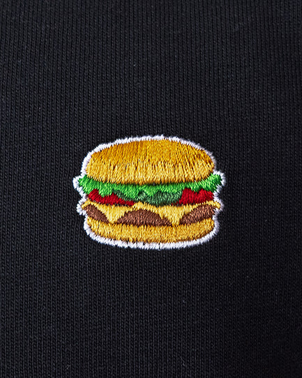 Nahaufnahme des gestickten Burger Motivs auf schwarzem T-Shirt