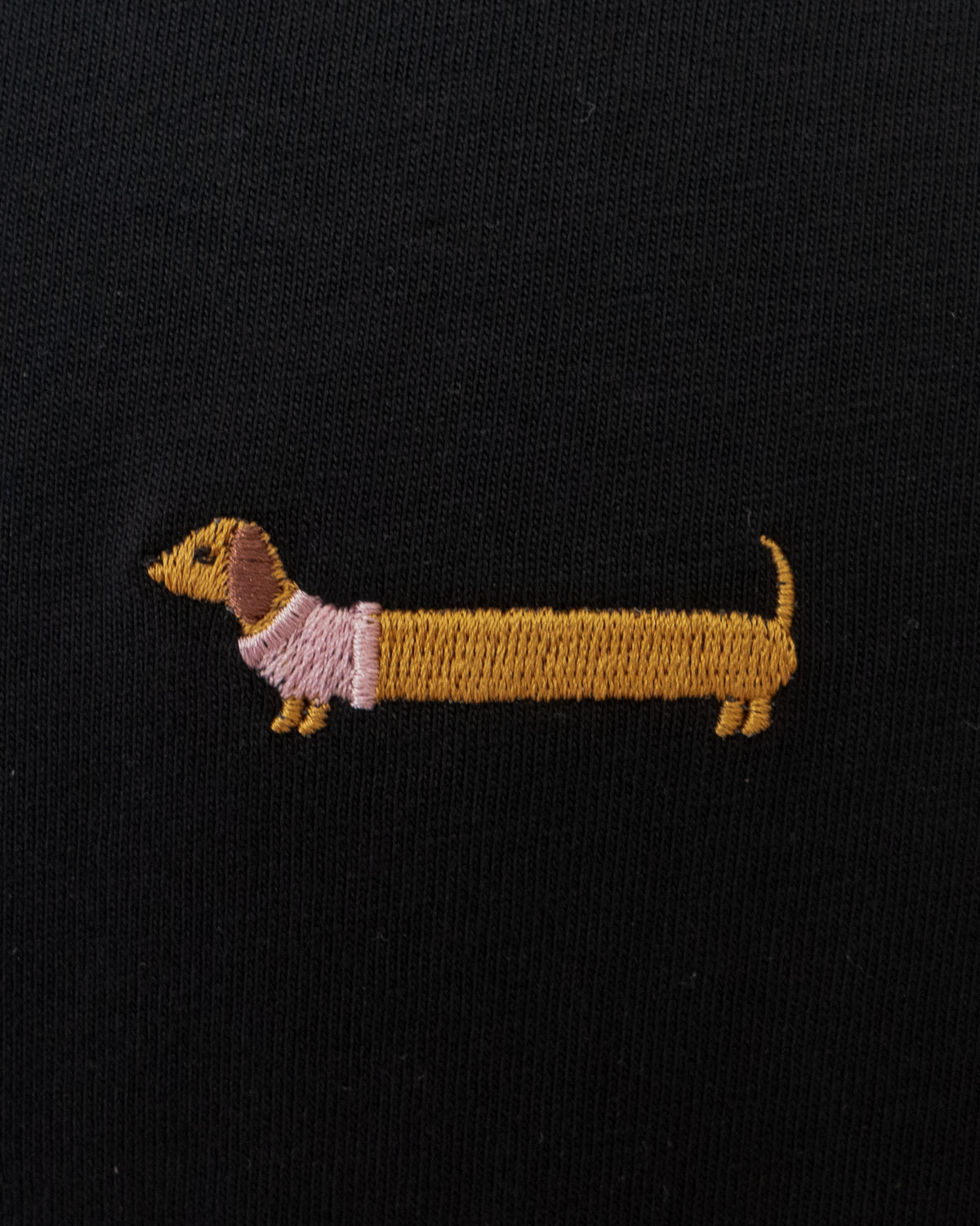 Nahaufnahme des gestickten Dackel Motivs auf schwarzem T-Shirt