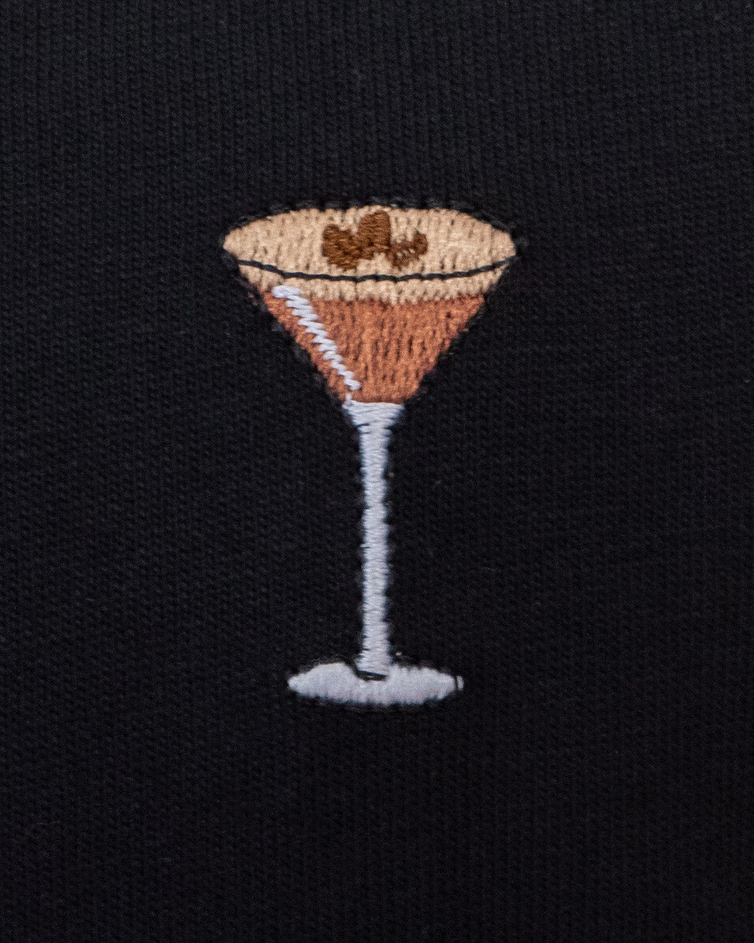 Nahaufnahme des gestickten Espresso Martini Motivs auf schwarzem T-Shirt