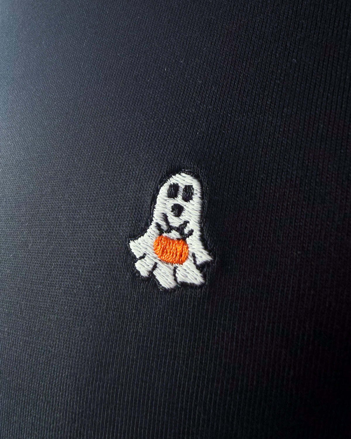 Nahaufnahme des gestickten Geist mit Kürbis Motiv auf schwarzem T-Shirt