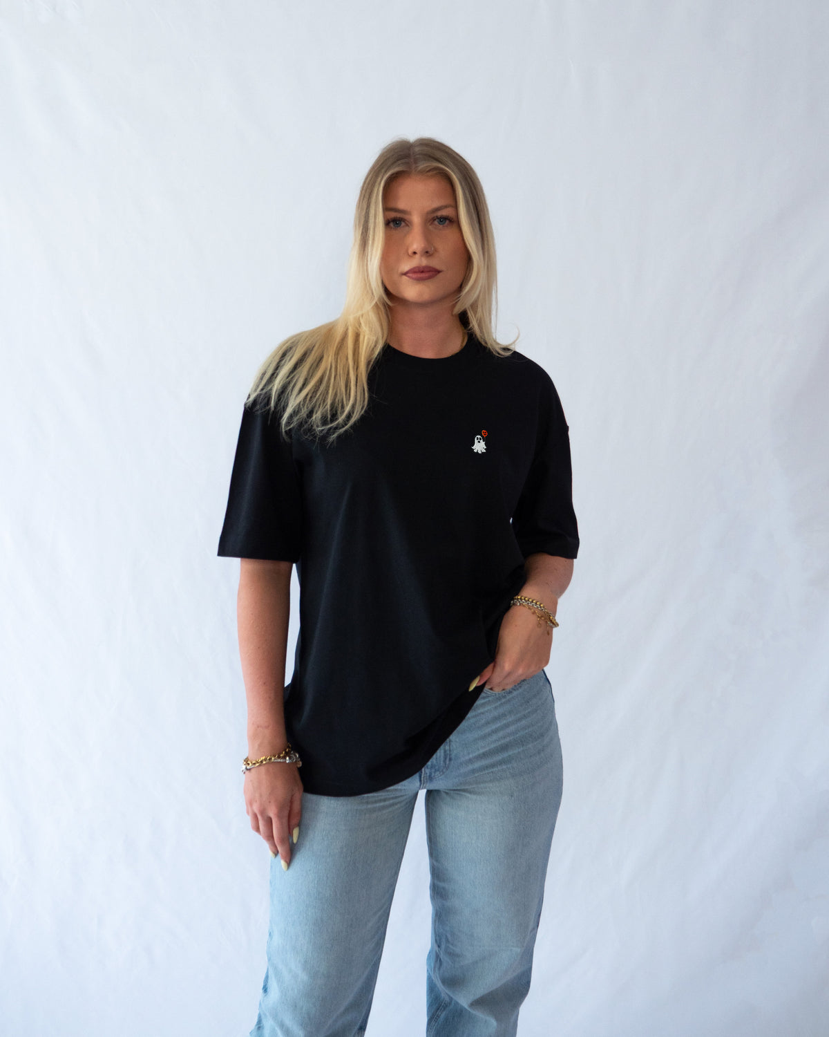 Das Model trägt ein schwarzes Bio-Baumwoll Shirt mit gesticktem Geist mit Luftballon Motiv