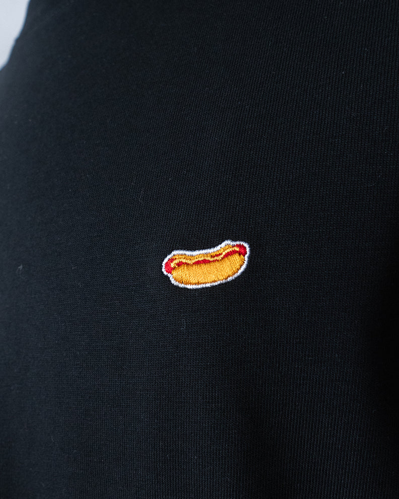 Nahaufnahme des gestickten Hot Dog Motivs auf schwarzem T-Shirt