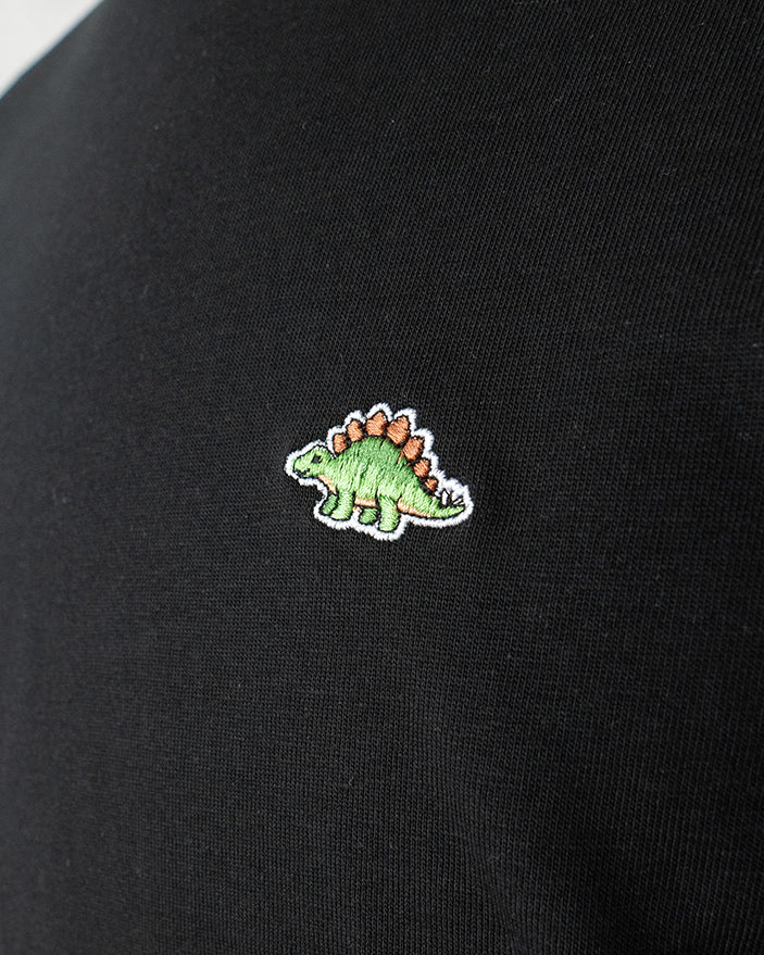 Nahaufnahme des gestickten Stegosaurus Motivs auf schwarzem T-Shirt