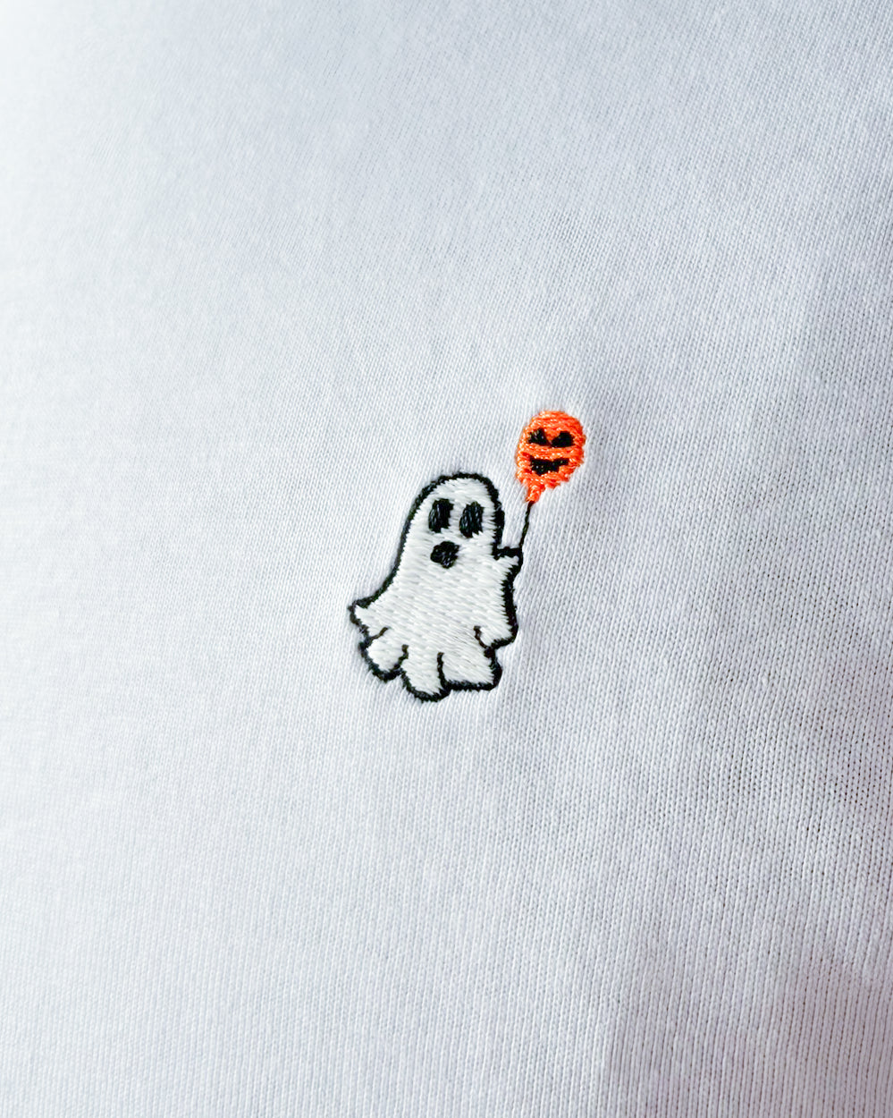 Nahaufnahme des gestickten Geist mit Luftballon Motiv auf weißem T-Shirt