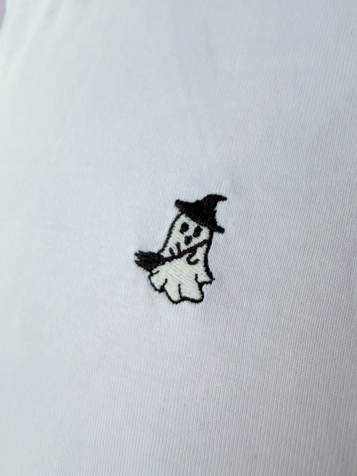 Nahaufnahme des gestickten Geist als Hexe Motivs auf weißem T-Shirt