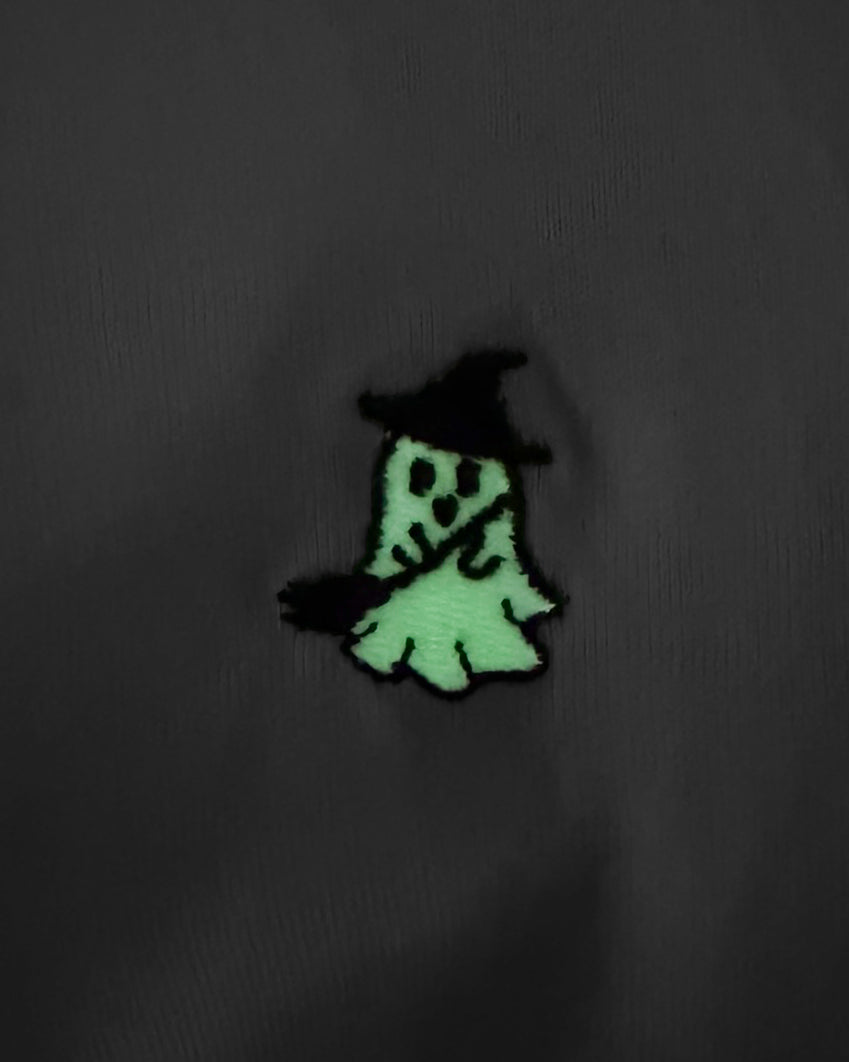 Nahaufnahme des leuchtenden gestickten Hexe Geist Motivs bei Dunkelheit