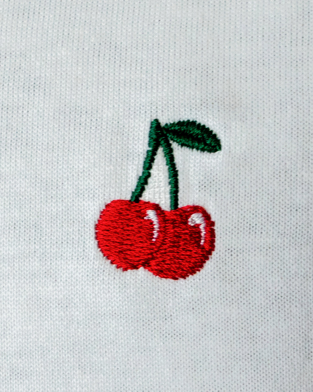 Nahaufnahme des gestickten Kirsche Motiv auf weißem T-Shirt
